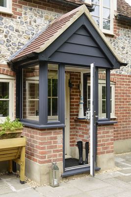 Dual coloured Anthracite Grey and Cream front door brick porch with uPVC windows and cream internal half glazed door with cottage bars