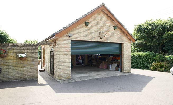 Electric double roller garage door in Fir Green opening from the Anglian garage door range