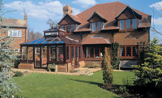 Large uPVC Edwardian conservatory in Dark Brown Woodgrain with leaded glass and roof feature from Anglian Home Improvements
