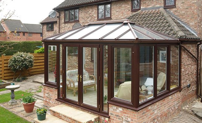 Edwardian style UPVC conservatory in dual Dark Woodgrain and White with large casement windows and French doors