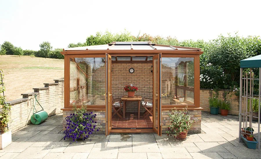 UPVC freestanding conservatory in Golden Oak with large casement windows and French doors from the Anglian conservatory range