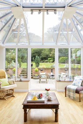 Inside UPVC Elizabethan conservatory finished in White with tall roof and French doors opening onto patio from Anglian Home Improvements