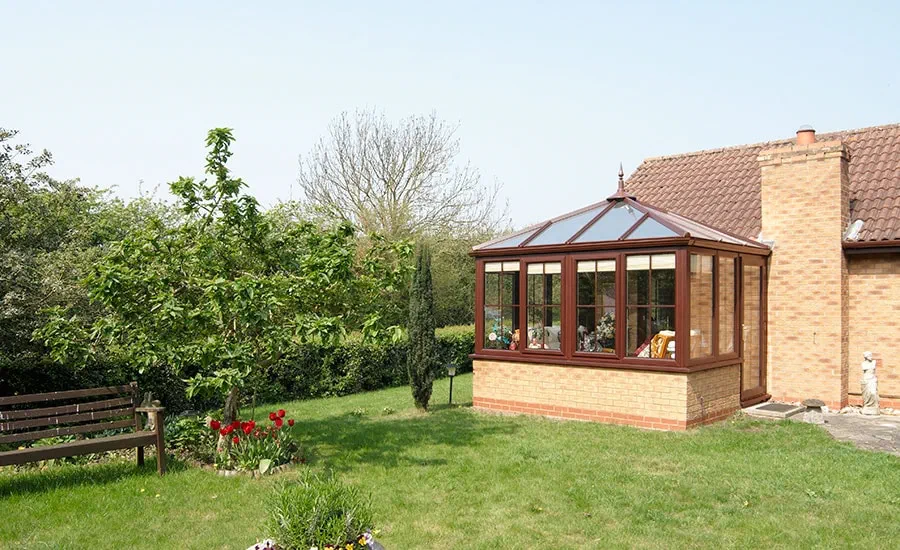 UPVC Elizabethan conservatory in Dark Woodgrain with fully glazed back door and windows with cottage bars from Anglian Home Improvements