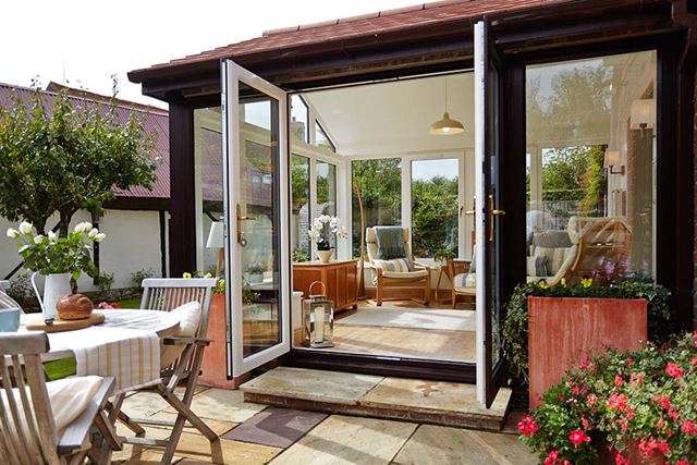 Dual dark woodgrain French doors on traditional tile extension