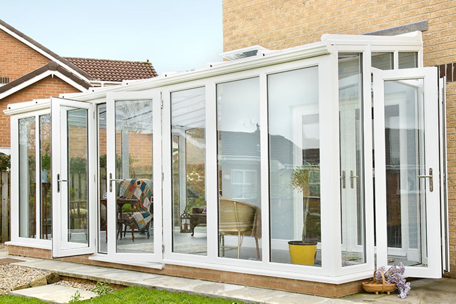 White UPVC lean to garden room conservatory with double French doors and large UPVC windows from Anglian Home Improvements