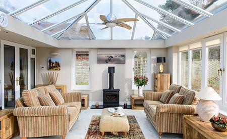 Modern orangery extension with large roof lantern and UPVC casement windows living room with log burner from Anglian Home Improvements