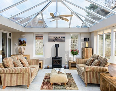 Traditional orangery extension with glass roof and white framing