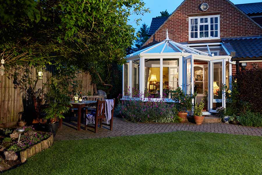 White uPVC harmony P-shaped conservatory at evening