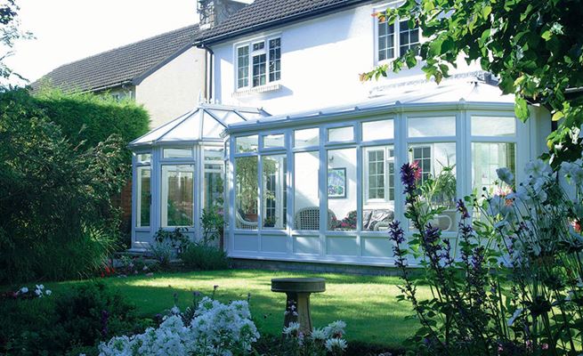 Large P-shaped conservatory in White UPVC with top hung casement windows and classic finials from the Anglian classic conservatory range
