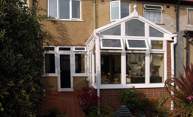 Regency UPVC conservatory finished in White Knight with shaped windows and top hung casement windows from the Anglian conservatories range