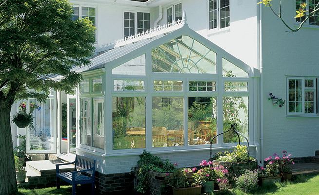 White UPVC Regency conservatory with sunburst decorative glass shaped windows and Georgian bar top hung casement windows