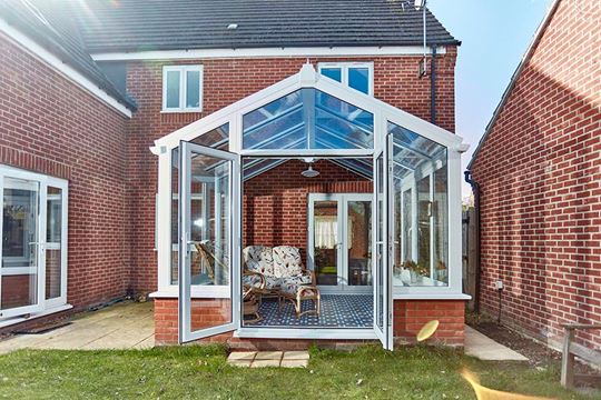 White uPVC regency conservatory with French doors in open position