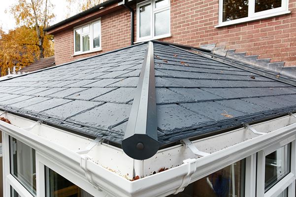 Close up of replacement conservatory roof finished with slate replica tiles and glass panel from the Anglian solid roof range