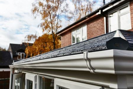 Close up of Edwardian solid roof conservatory with replica slate tiled roof and white ogee guttering from Anglian Home Improvements