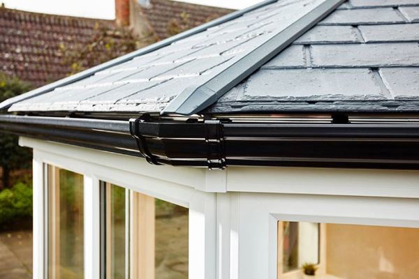Close up of solid roof Victorian conservatory with replica slated tiled roof and black ogee guttering from Anglian Home Improvements