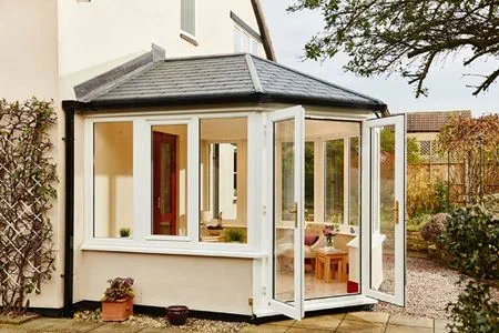 White UPVC solid roof conservatory with replica slate tiled roof