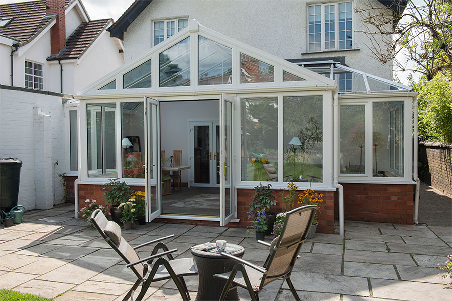 White uPVC T Shaped Harmony conservatory with French doors and tilt and turn windows in open positio