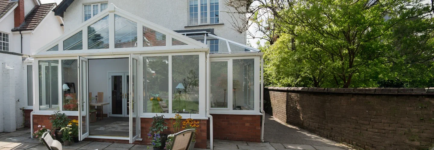 White uPVC T Shaped Harmony conservatory with French doors and tilt and turn windows primary banner