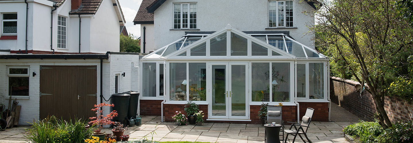 White uPVC T Shaped Harmony conservatory with French doors and tilt and turn windows secondary banne
