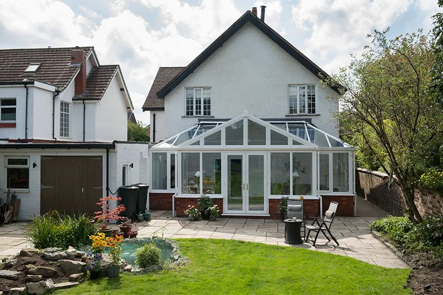 White uPVC T Shaped Harmony conservatory with French doors and tilt and turn windows