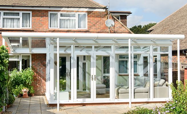 White UPVC garden room Veranda conservatory with French doors and floor to ceiling casement windows from the Anglian conservatory range