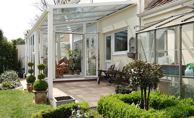 White UPVC Veranda conservatory with French doors opening onto patio from the Anglian veranda conservatory range