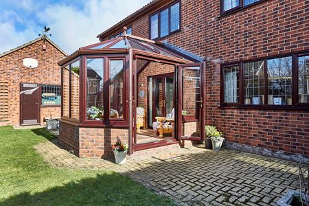 Dark woodgrain uPVC Victorian conservatory with French doors and casement windows