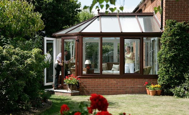 Dual colour Dark Woodgrain and White UPVC Victorian style conservatory with tilt and turn windows from Anglian Home Improvements