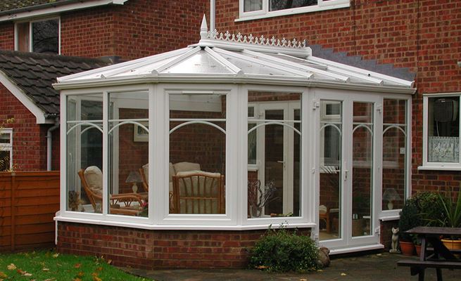 White Knight UPVC Victorian conservatory with decorative finial and curved Georgian bar windows and French door design