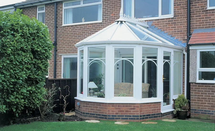 White UPVC Victorian style conservatory with single glazed back door and casement windows with curved Georgian window bars