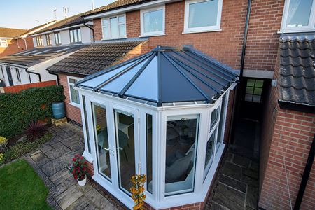 White uPVC Victorian conservatory with French doors and solid panel roof