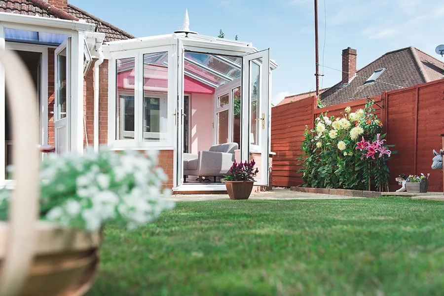 White uPVC victorian conservatory with french doors in open position