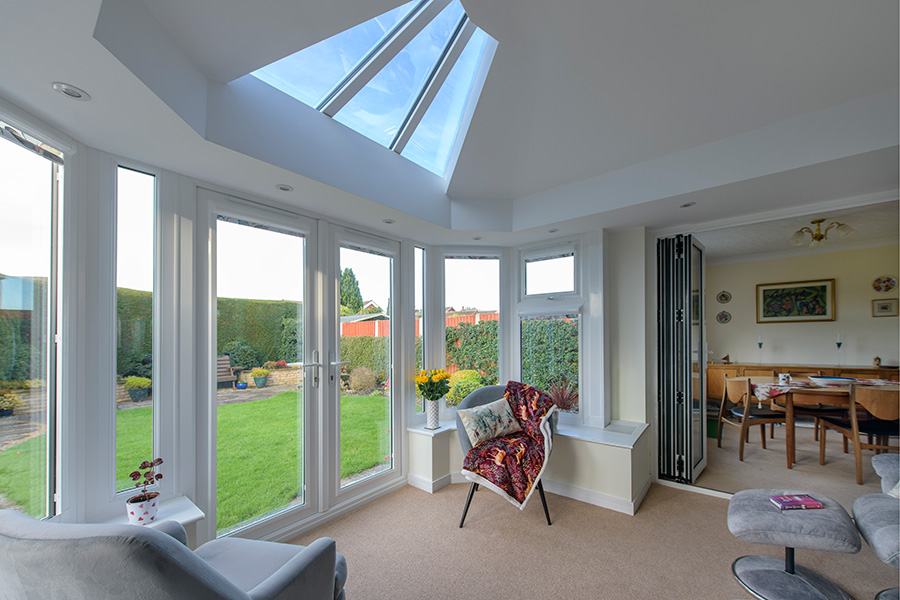 White uPVC victorian conservatory with interior bifold doors and French doors