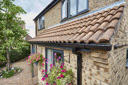 Black uPVC guttering and anthracite grey windows front of house