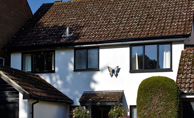 Front of house view of Black uPVC guttering and downpipes from the Anglian guttering range