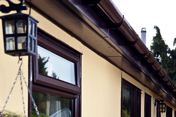 Brown uPVC guttering and downpipes with matching soffits and fascias from the Anglian rooftrim range
