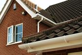 White uPVC guttering and downpipes and a gable end bargeboard from the Anglian rooftrim range