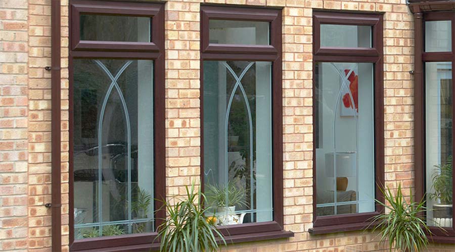 Dual dark woodgrain and white uPVC coloured windows with etched glass decoration