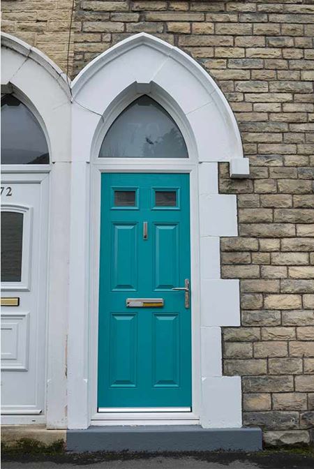 Gothic arch shaped window over turquoise blue front door