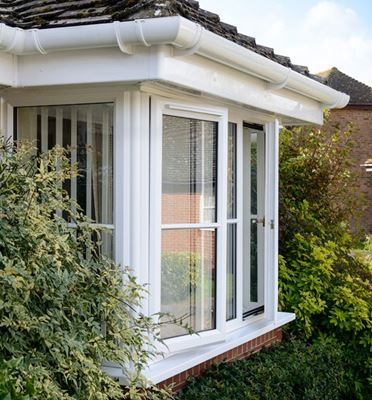 Open White UPVC bay casement window with cottage bars and matching White UPVC guttering from Anglian Home Improvements