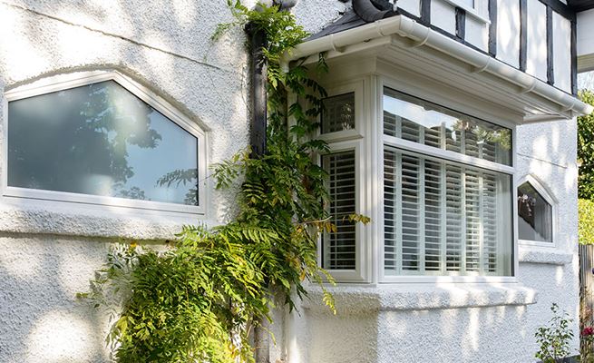 White uPVC square bay front window with blinds from the Anglian bay window range