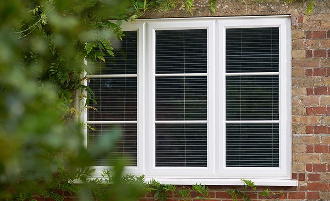 Exterior view of white double glazed UPVC casement window with blinds from the Anglian casement window range