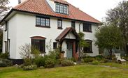 Black timber double glazed casement windows and wooden front door with georgian bars from the Anglian wooden windows and doors range