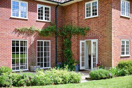Cream timber casement windows with Georgian insert bars and French doors