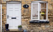 Cream wooden casement window with cottage bars and monkeytail handle and matching traditional door from Anglian Home Improvements