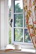 Close up of White timber cottage window with black window handle from the Anglian cottage window range