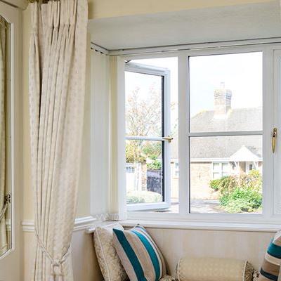 Double glazed White UPVC casement window with cottage bar inserts and gold window handles from Anglian Home Improvements