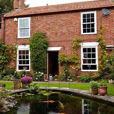 Country house white wooden sash window replacement with Cottage bars from the Anglian sash windows range