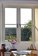 Timber cottage window finished in White with centre mullion and black window handles from Anglian Home Improvements