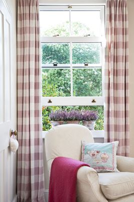 White UPVC sash window in living room with gold window furniture from the Anglian sliding sash window range